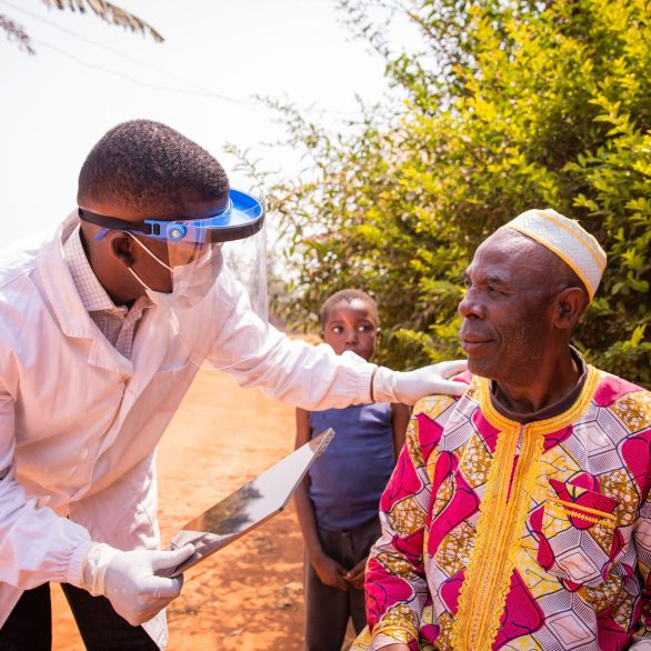 A doctor wearing a mask. talks to a patient